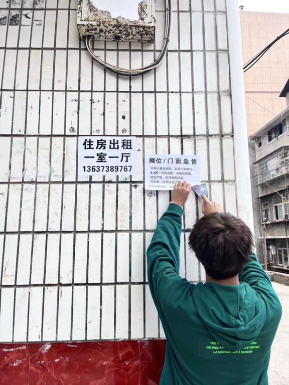(志愿者们正在铲除小广告)