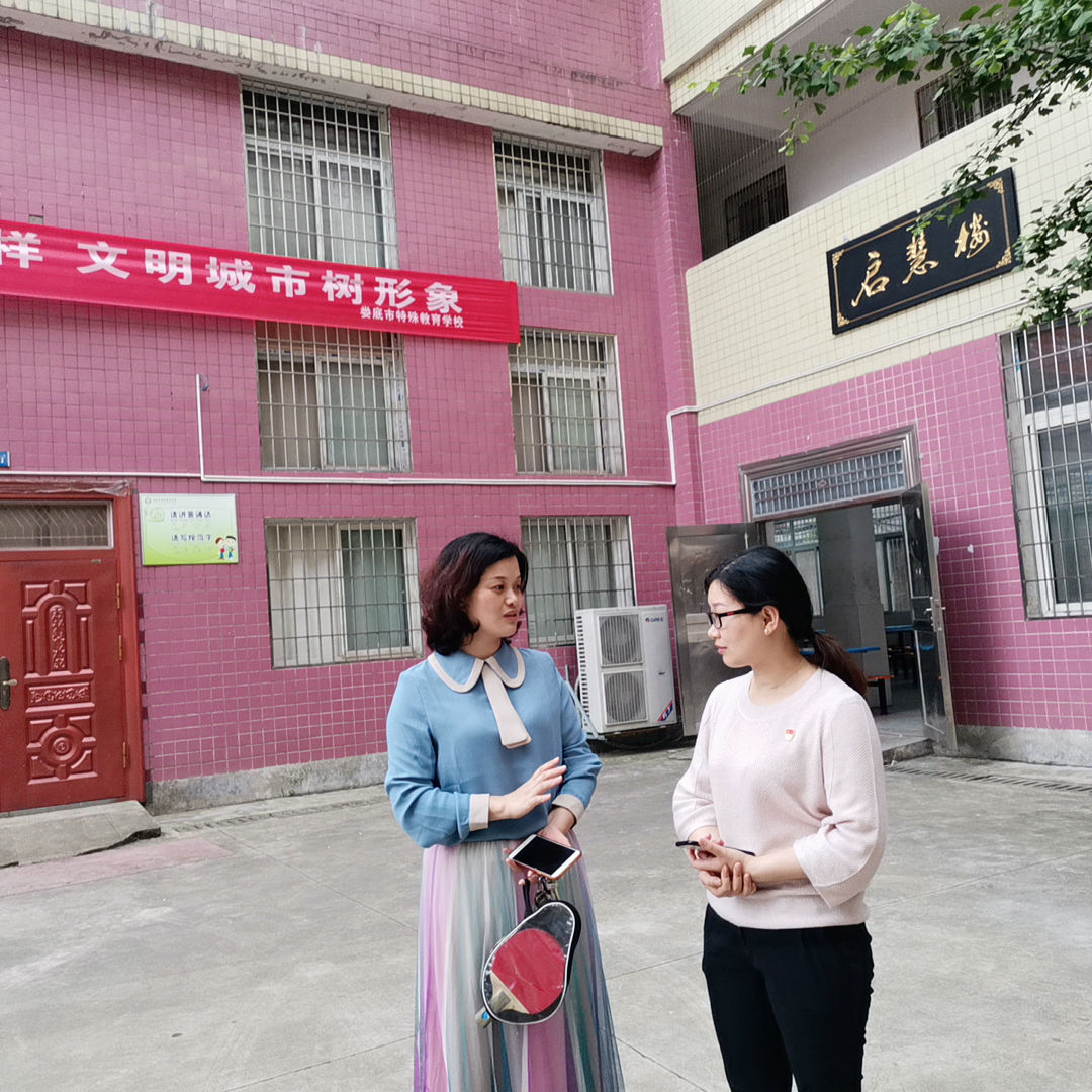 (我院学生第二党支部书记朱燕聪与特殊学校校长交谈学生情况)